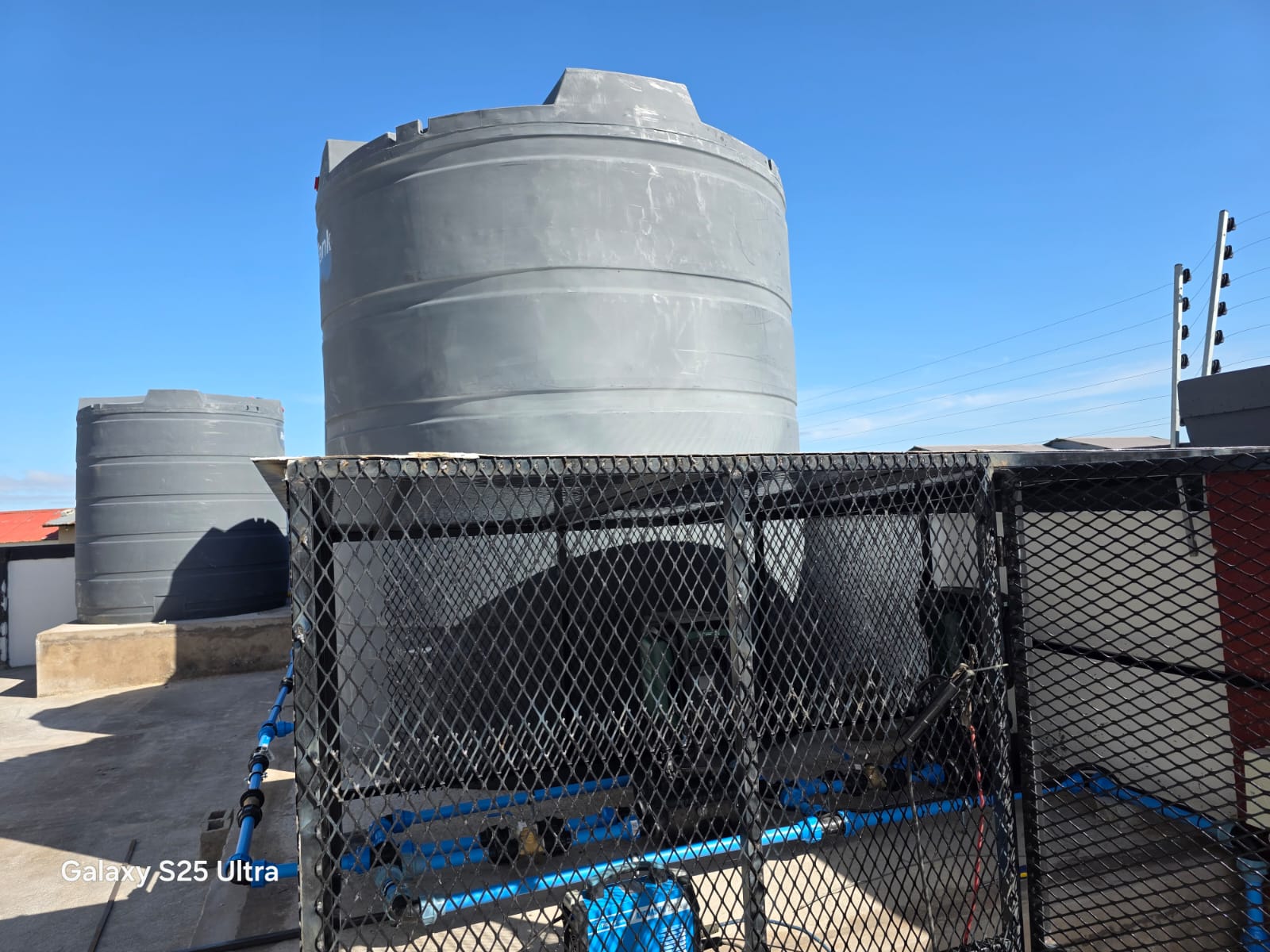 Backup water storage tanks and pump housing on the residence roof